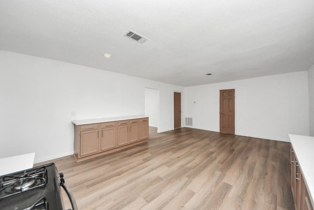 unfurnished living room featuring light hardwood / wood-style flooring and a textured ceiling