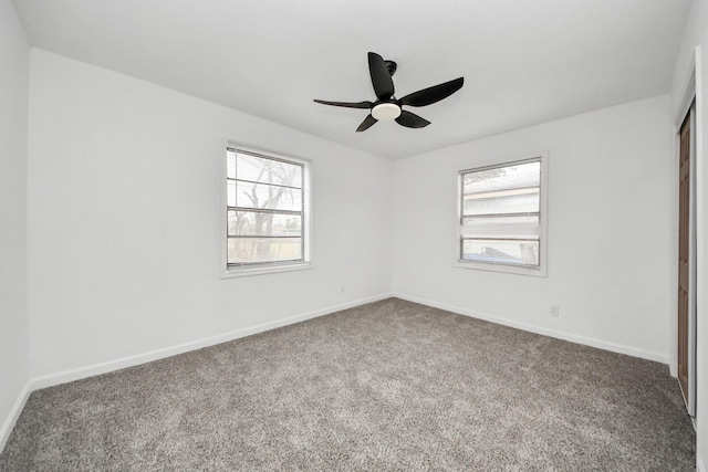 spare room with ceiling fan and carpet