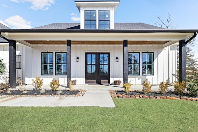 view of front facade with a porch, a front yard, and french doors