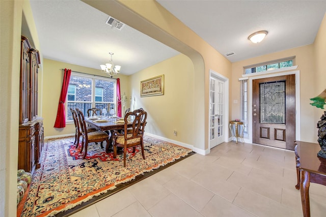 dining space with light tile patterned floors and a notable chandelier