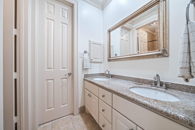 bathroom featuring double vanity, ornamental molding, a sink, and tile patterned floors