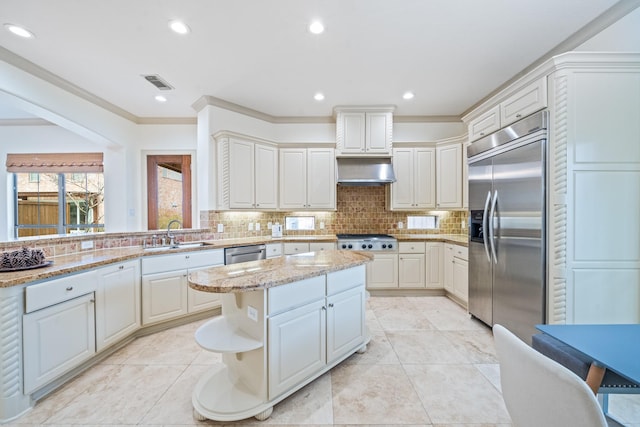 kitchen featuring under cabinet range hood, a sink, visible vents, appliances with stainless steel finishes, and a center island