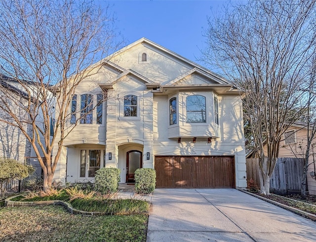 view of front of house featuring concrete driveway, fence, and an attached garage