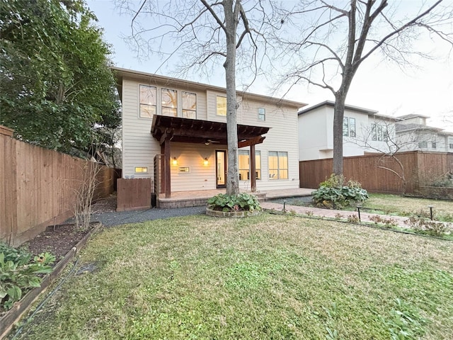 back of property with a patio area, a fenced backyard, and a lawn