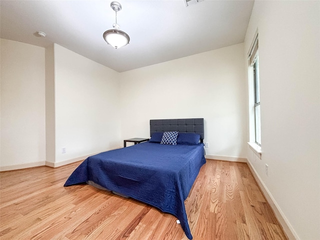 bedroom with baseboards and wood finished floors