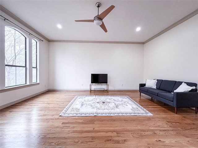 living area featuring baseboards, ornamental molding, wood finished floors, and recessed lighting