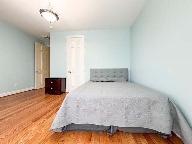 bedroom with wood finished floors and baseboards