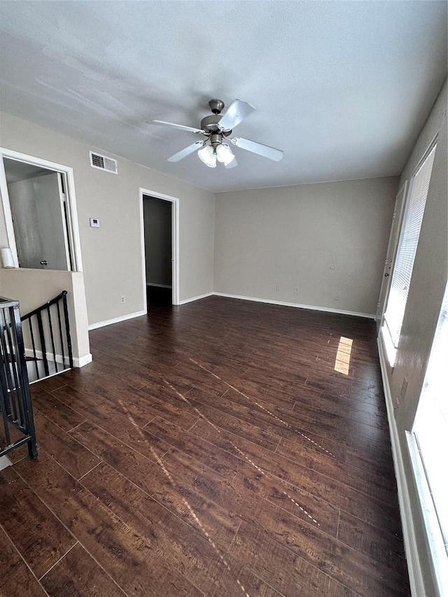 empty room with ceiling fan and dark hardwood / wood-style flooring