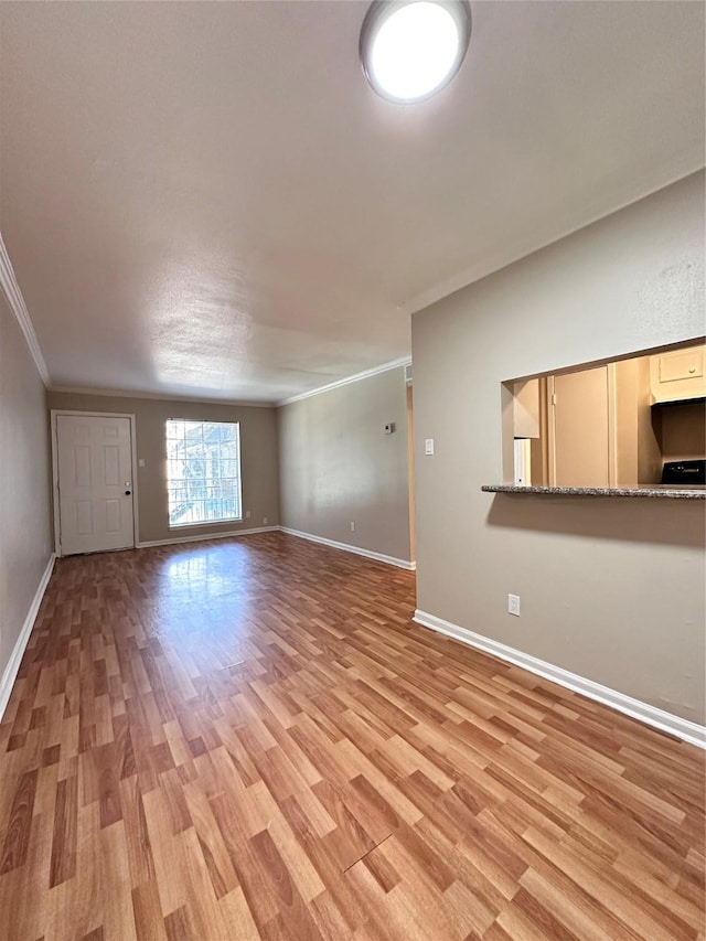 unfurnished living room featuring crown molding and light hardwood / wood-style flooring