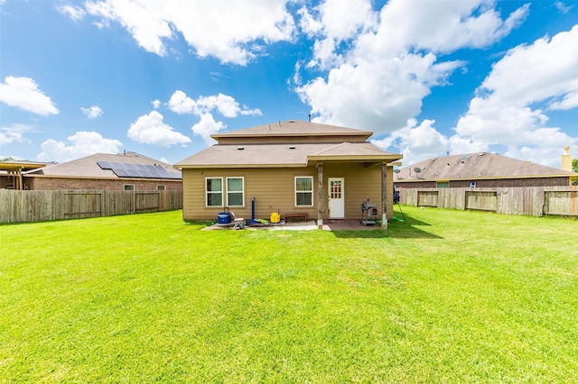 rear view of house featuring a yard and a patio