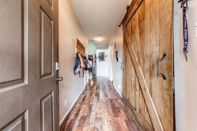 hall featuring dark hardwood / wood-style floors and a barn door