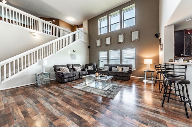 living room with dark hardwood / wood-style flooring and a high ceiling