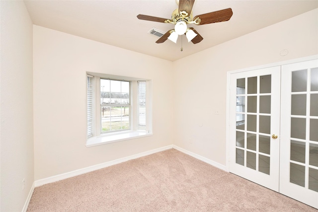 spare room featuring light colored carpet, french doors, and ceiling fan