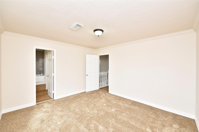 carpeted empty room with crown molding and a textured ceiling