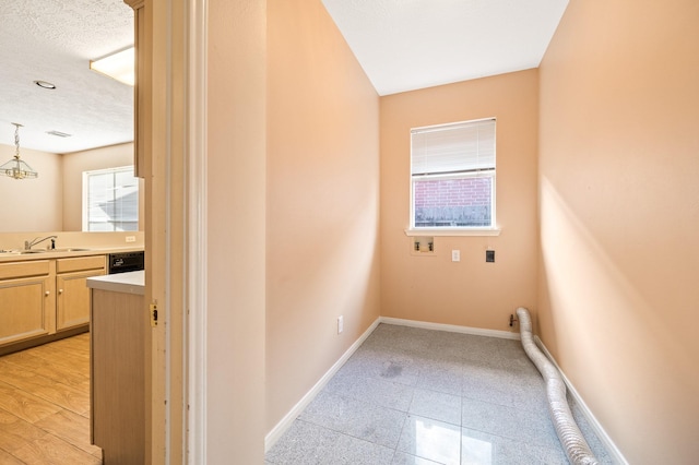 clothes washing area with washer hookup, sink, and a textured ceiling