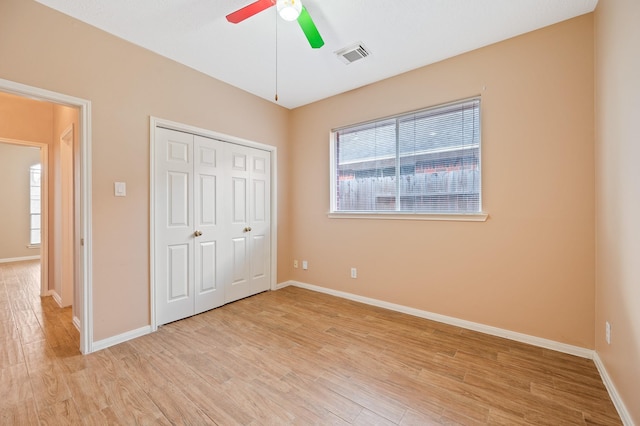 unfurnished bedroom featuring a closet, ceiling fan, and light wood-type flooring