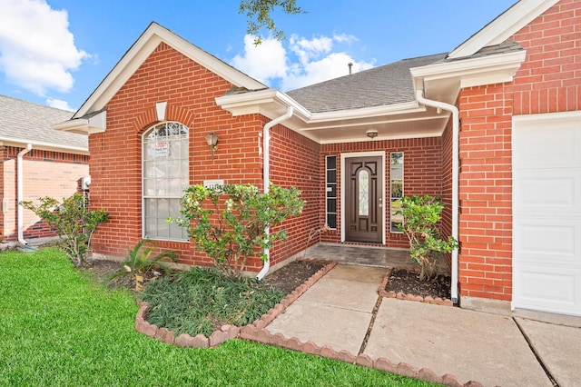 entrance to property with a garage and a yard