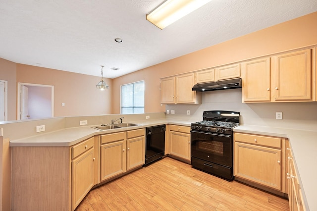 kitchen with sink, pendant lighting, kitchen peninsula, and black appliances