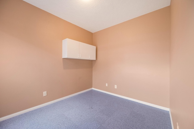 spare room with a textured ceiling and carpet