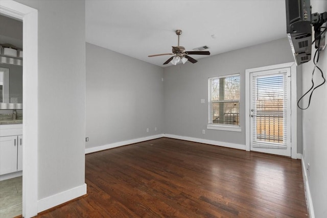 empty room with dark hardwood / wood-style flooring, sink, and ceiling fan