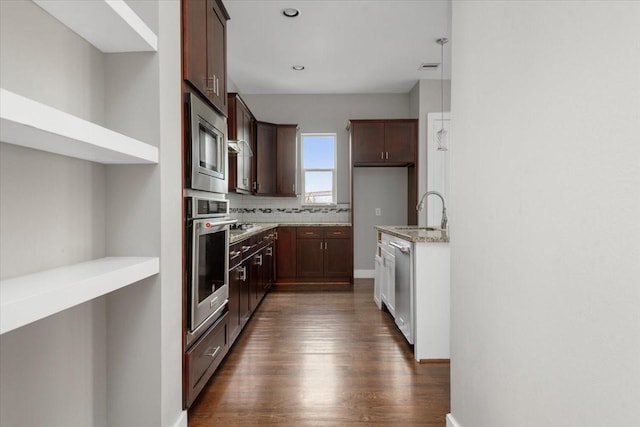 kitchen featuring sink, light stone counters, tasteful backsplash, appliances with stainless steel finishes, and dark hardwood / wood-style floors