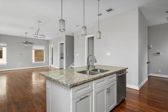 kitchen featuring sink, white cabinets, stainless steel dishwasher, light stone counters, and a center island with sink