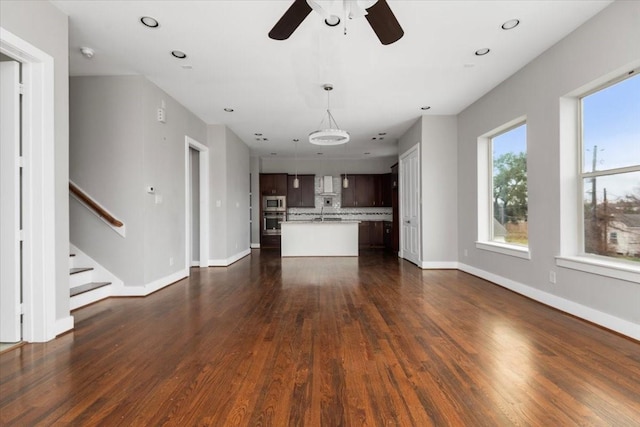 unfurnished living room with dark wood-type flooring and ceiling fan