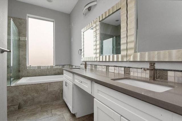 bathroom featuring vanity, a healthy amount of sunlight, tiled bath, and tile patterned floors