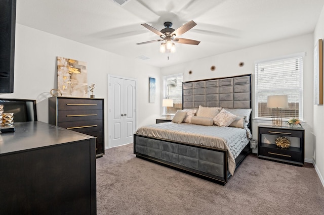 carpeted bedroom with ceiling fan and a closet