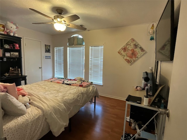 bedroom with ceiling fan and dark hardwood / wood-style flooring