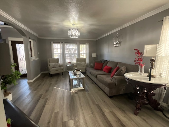 living room featuring crown molding, hardwood / wood-style floors, and a chandelier