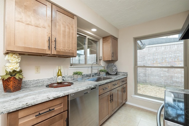 kitchen featuring sink, light stone counters, a textured ceiling, light tile patterned floors, and dishwasher