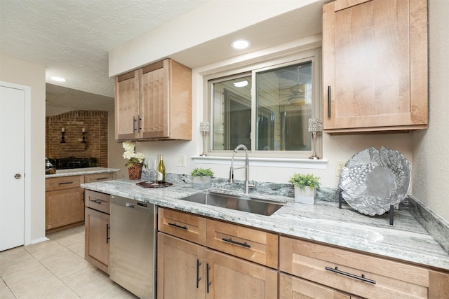 kitchen featuring sink, light stone countertops, a textured ceiling, light tile patterned flooring, and stainless steel dishwasher