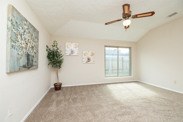 carpeted spare room featuring ceiling fan, lofted ceiling, and a textured ceiling