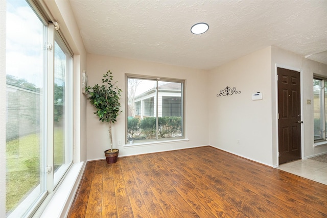 empty room featuring a textured ceiling and light wood-type flooring