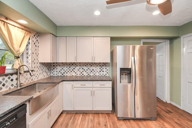 kitchen featuring sink, white cabinetry, black dishwasher, stainless steel refrigerator with ice dispenser, and light wood-type flooring