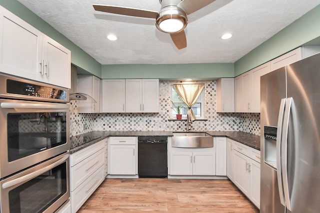 kitchen featuring sink, white cabinets, ceiling fan, and black appliances