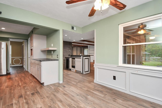 kitchen featuring beverage cooler, refrigerator, light wood-type flooring, and white cabinets