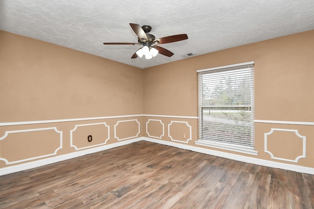 empty room with hardwood / wood-style flooring, ceiling fan, and a textured ceiling