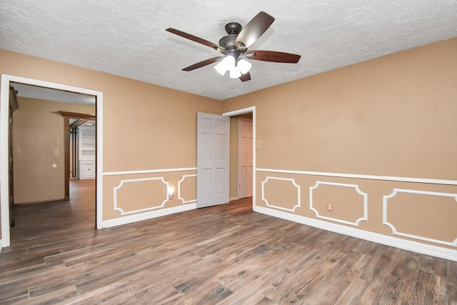 empty room featuring ceiling fan, hardwood / wood-style floors, and a textured ceiling