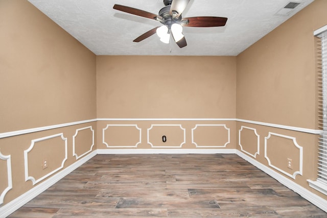 unfurnished room with ceiling fan, hardwood / wood-style flooring, and a textured ceiling