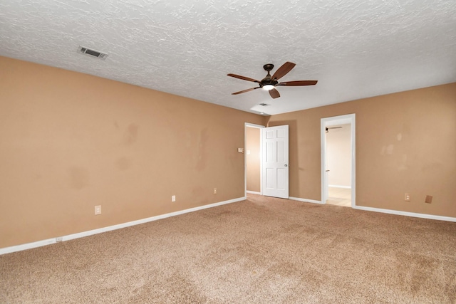 empty room with carpet floors, a textured ceiling, and ceiling fan