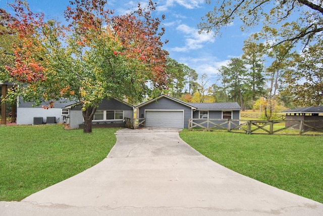 ranch-style home with central AC unit, a garage, and a front yard