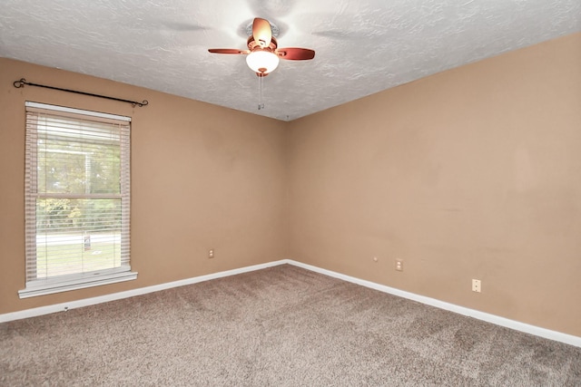 carpeted empty room with ceiling fan and a textured ceiling