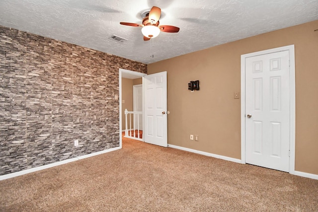 spare room with ceiling fan, carpet, and a textured ceiling