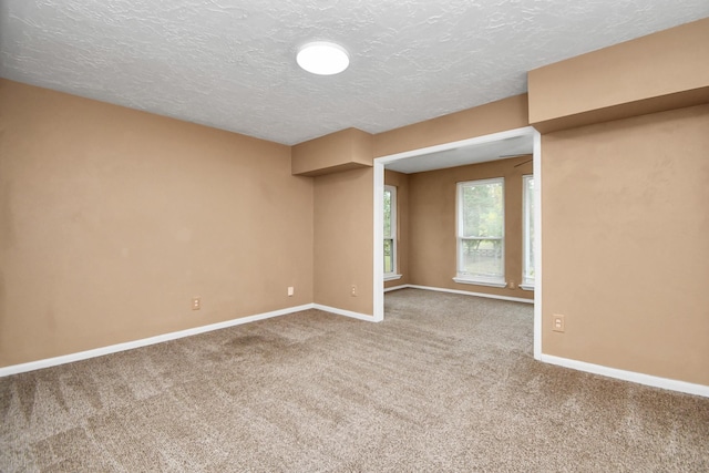 carpeted spare room with a textured ceiling