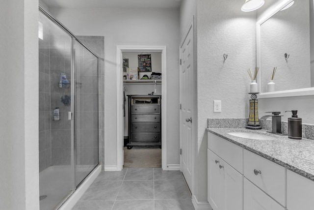 bathroom with tile patterned flooring, vanity, and an enclosed shower