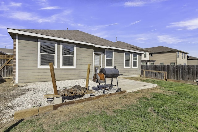 back of house featuring a patio area and a lawn