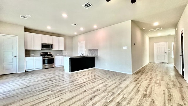 kitchen featuring white cabinetry, sink, light wood-type flooring, and appliances with stainless steel finishes