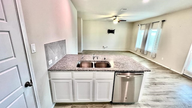 kitchen with sink, white cabinetry, stone countertops, light wood-type flooring, and dishwasher